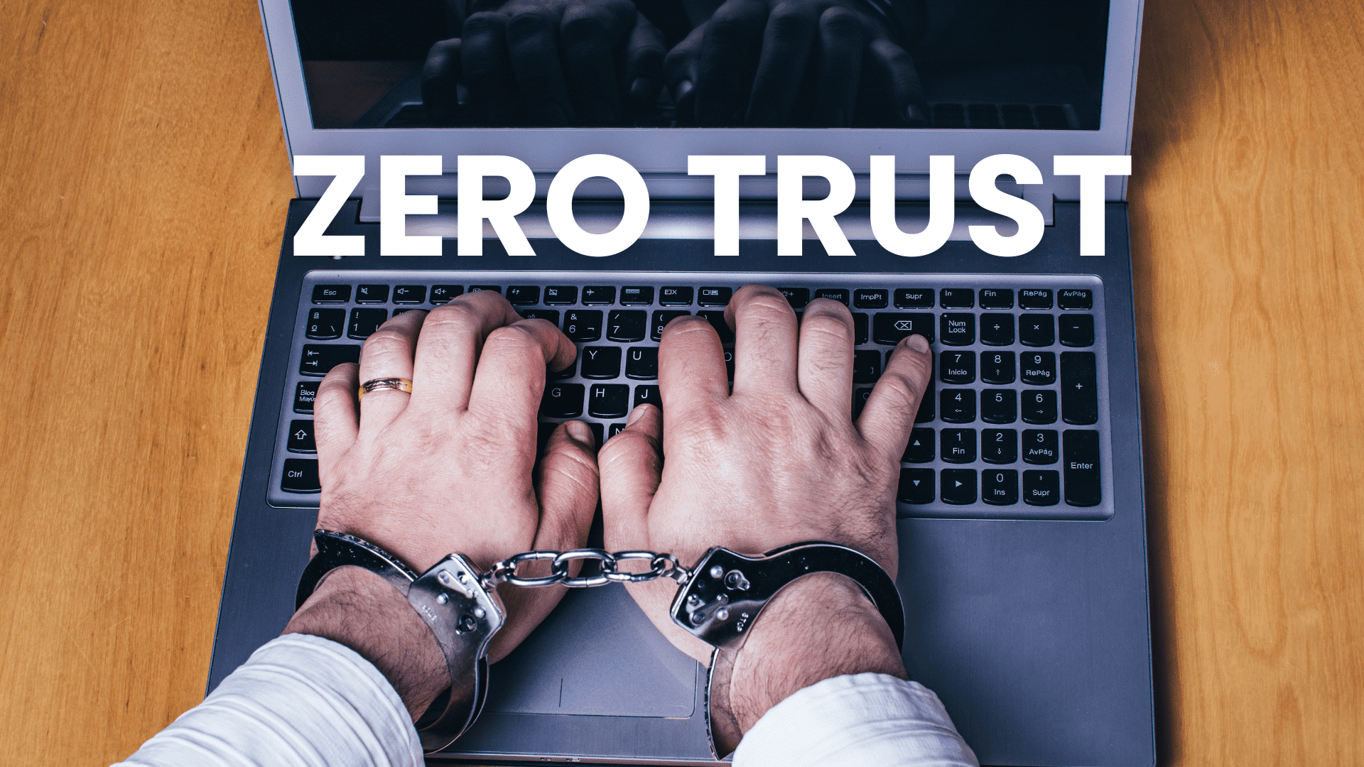Mains menottées sur un clavier, illustration du modèle de cybersécurité Zero Trust